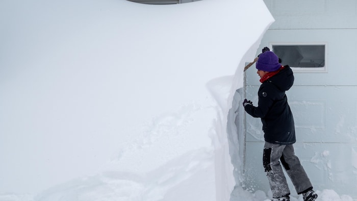 Un banc de neige qui dépasse un enfant.