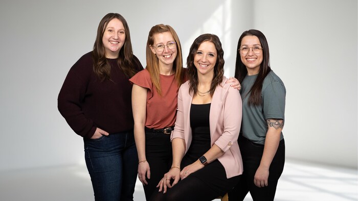 Quatre femmes sourient pour la photo. 