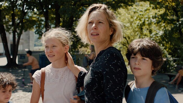 A woman and three children in a park. Image from the film The Courageous.