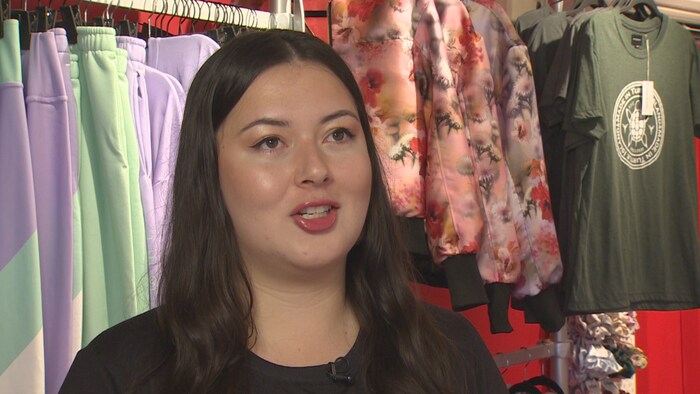 Lesley Hampton devant une collection de vêtements.