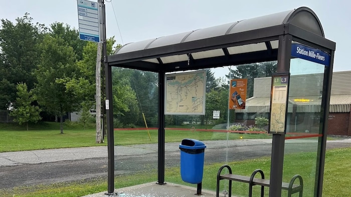 Un abribus et un amas de vitre cassée au sol.