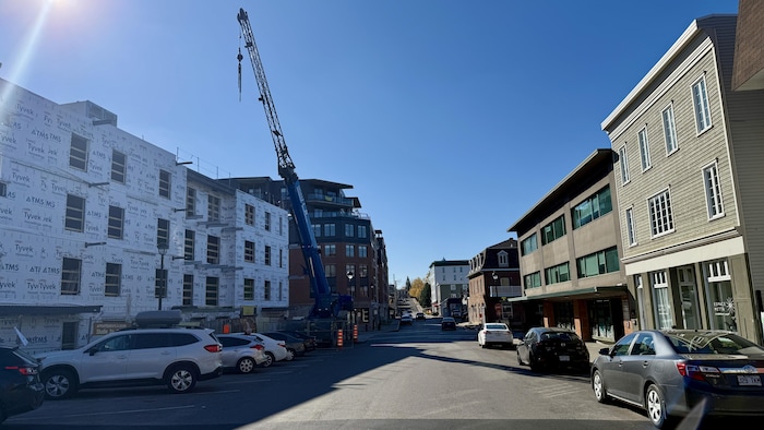Une rue résidentielle dans le Vieux-Lévis avec des habitations en construction et des voitures stationnées.