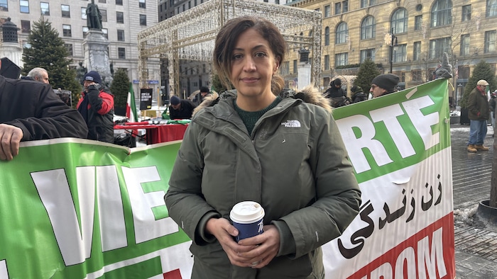 Leyla Ebrahimi devant une banderole lors d'une manifestation.