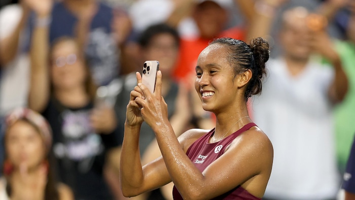 Elle prend une photo sur le terrain après sa victoire
