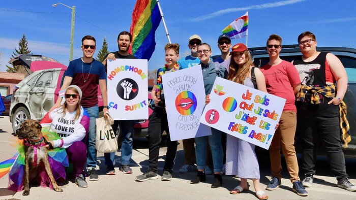 Un groupe de personne avec des drapeaux et des pancartes.