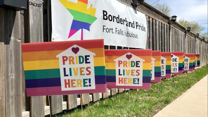 Des drapeaux de la Fierté avec Pride Lives Here d'écrit.