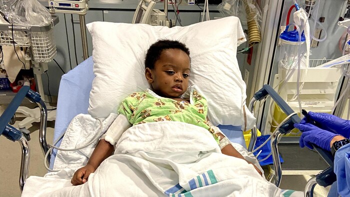 Un petit garçon sur un lit de l'hôpital. 