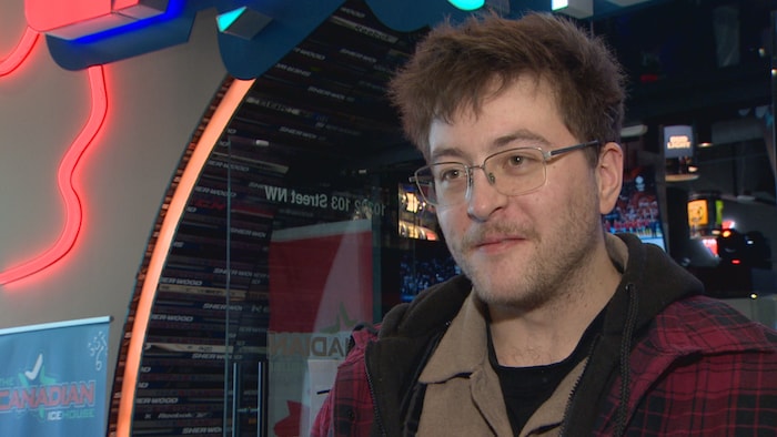 Une jeune homme lors d'une entrevue, à la sortie du bar Real Canadian Icehouse d'Edmonton. L'émotion se lit sur son visage.