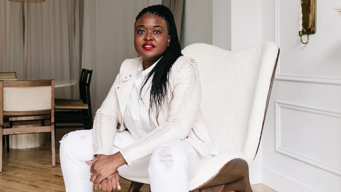 Lianne Hannaway, DG de l'Association des entreprises et des professionnels noirs, assise sur un divan blanc, habillée en blanc, le regard franc pour une photo portrait