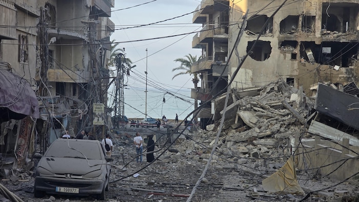 Des personnes inspectent les lieux d'une frappe israélienne dans la ville côtière de Tyr.