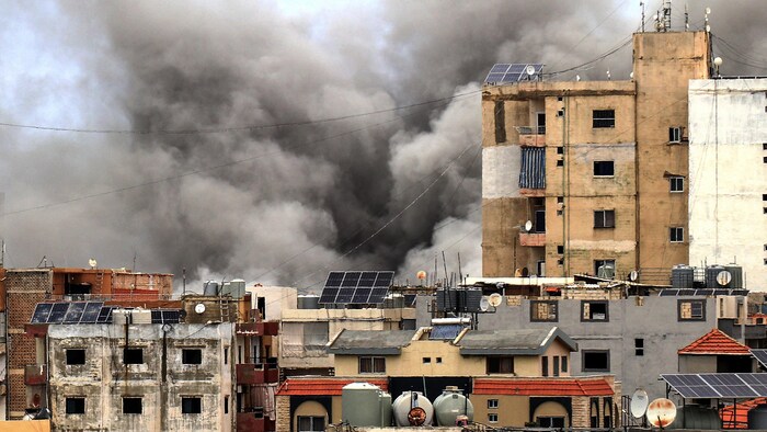 De la fumée s'élève derrière des bâtiments à la suite d'une frappe aérienne israélienne dans la ville de Tyr, dans le sud du pays, le 15 mai 2026.