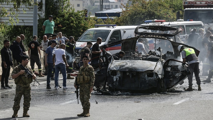 Les premiers secours interviennent près d'un véhicule touché par une frappe de drone israélien sur une autoroute près de la ville de Jiyeh, au sud de Beyrouth, le 13 mai 2026.