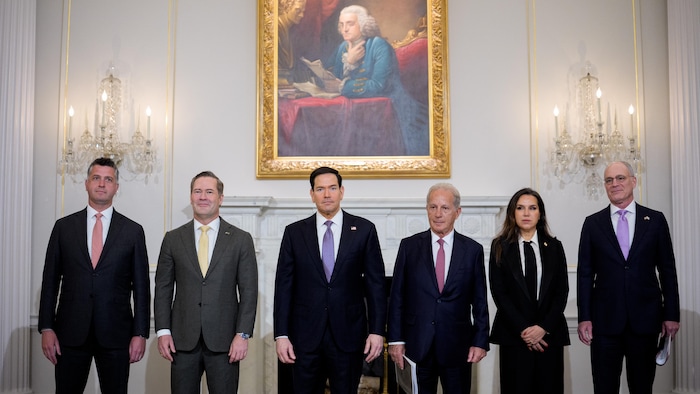 Cinq hommes et une femme debout pour prendre une photo.