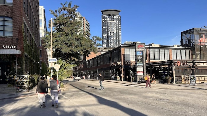 Des passants traversent à l'intersection des rues Liberty et l'avenue Hanna.