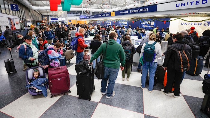 Un groupe de personnes be  dans un aéroport.