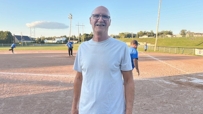 Gilles Michaud pose pour la photo sur un terrain de baseball.