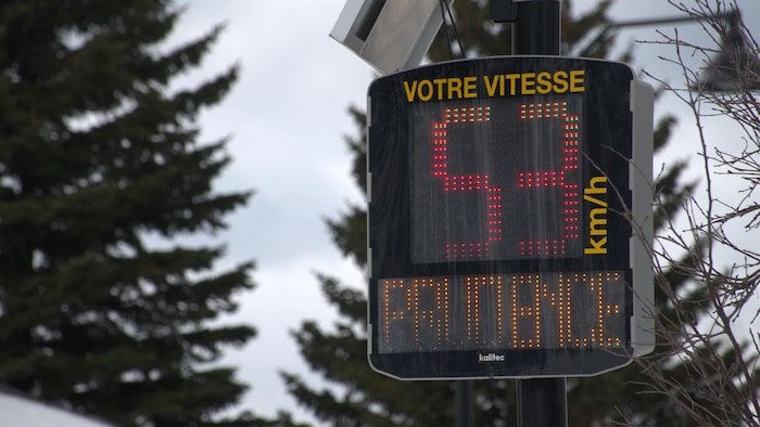 Un radar pédagogique affiche la vitesse de 53 kilomètres/heure avec le message « prudence ».