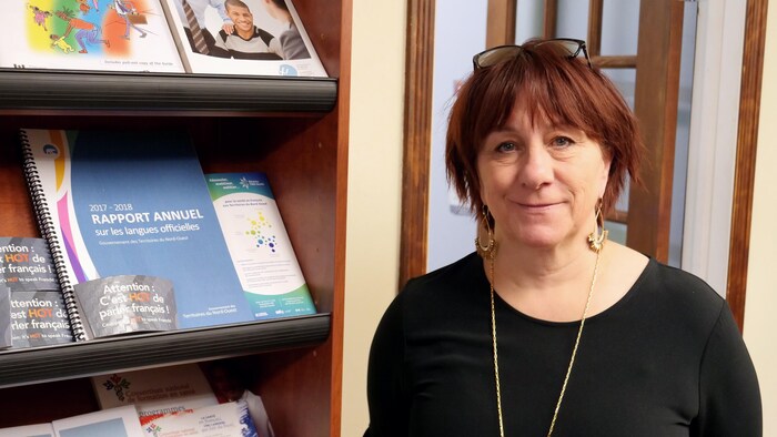 Une femme sourit pour la caméra.