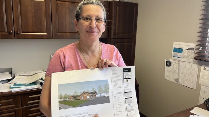 Une femme montre un document contenant les détails des travaux prévus au CPE. 