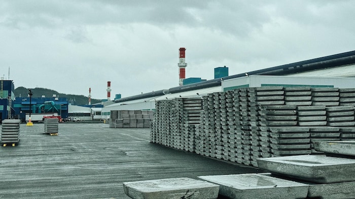 Des lingots d'aluminium à l'extérieur, dans la cour d'une aluminerie.