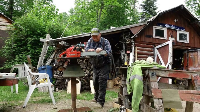 Lionel Lacroix travaille le bois devant son chalet.