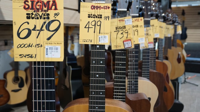 Des guitares sont suspendues à des crochets dans un magasin de musique.