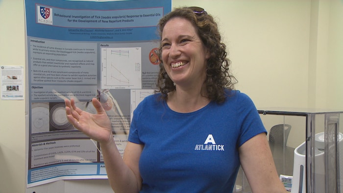 Lisa Ali dans un laboratoire portant un t-shirt annonçant son produit, AtlanTick.