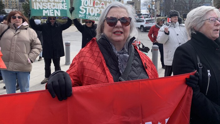 Lise Brown avec un drapeau canadien dans ses mains.