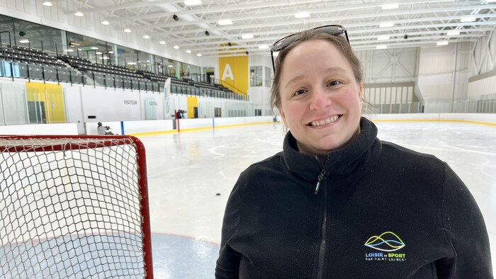 Lise Arsenault pose près d'un filet de hockey sur une patinoire.
