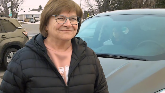 Portrait de Lise Desormeaux debout devant une voiture.