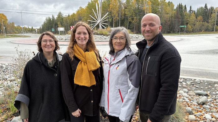 Trois femmes et un homme posent souriants pour la photo.