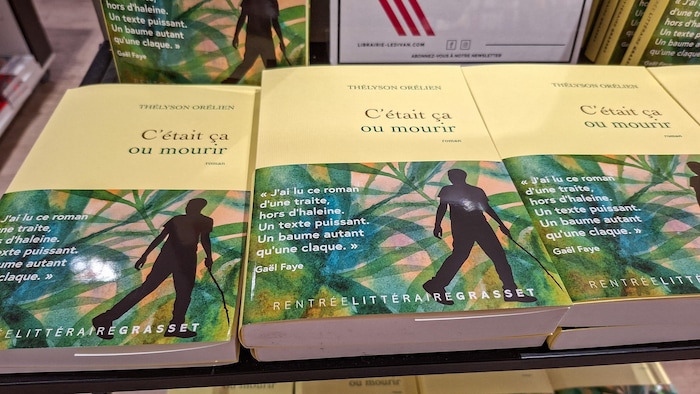 Des exemplaires du roman « C'était ça ou mourir », de Thélyson Orélien, sont exposés sur une table de librairie.
