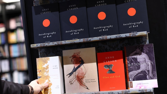 Des copies de livres d'Anne Carson, « Autobiography of Red », « Glass and God », « Wrong Norma », « Eros the Bittersweet » et « If not, Winter » dans un étalage de librairie.