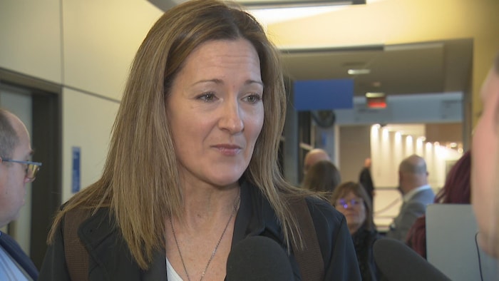 Une femme parle dans un micro.