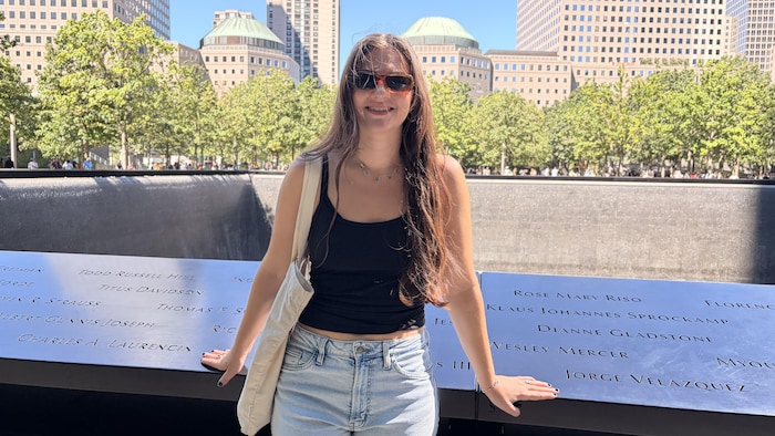 Une jeune femme souriante pose sur le site du mémorial.