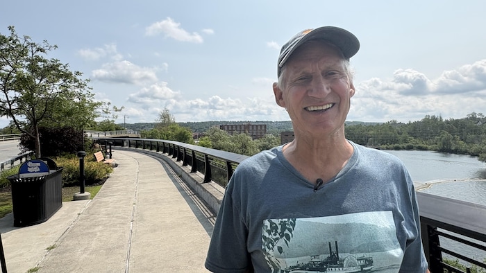 Un homme sur une passerelle près d'une rivière.