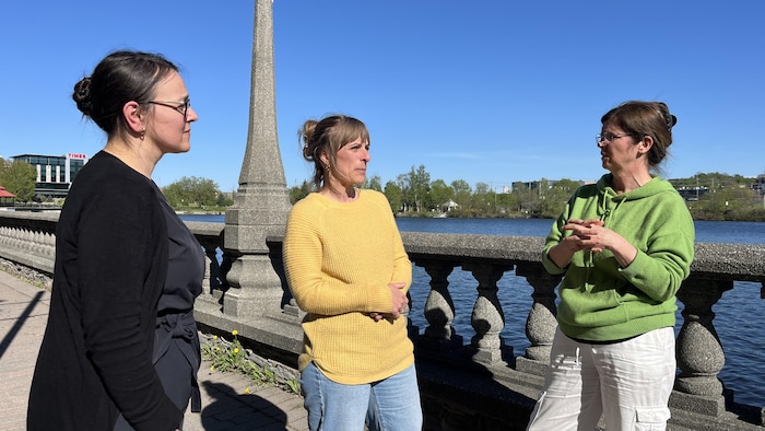 Les autres femmes discutent ensemble devant le lac des Nations.