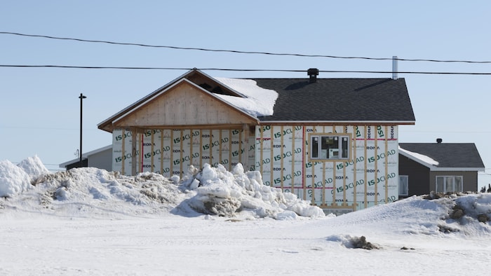 Une maison en construction avec de la neige autour.