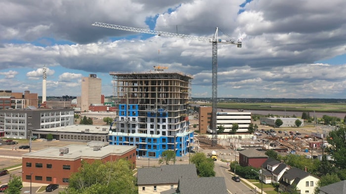 Une tour en construction avec une grue. 