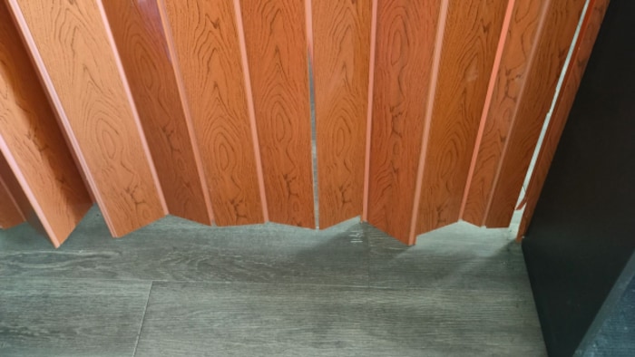 Une porte pliante en bois qui ne touche pas le sol. 