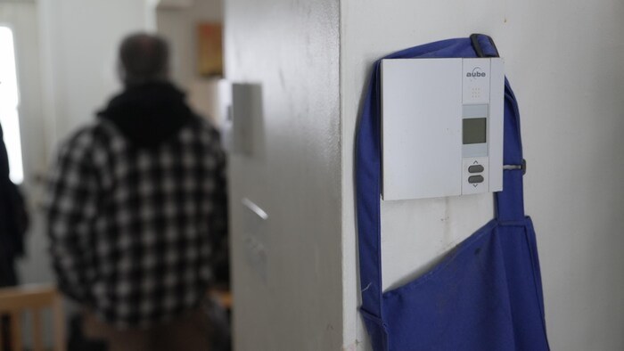 Un thermostat sur un mur d’un logement est éteint.