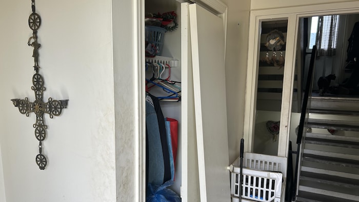 Une entrée d'un logement, une porte d'un garde-robe brisé.