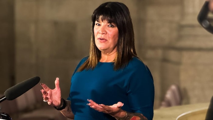 Bernadette Smith est debout et parle en faisant des gestes des deux mains.