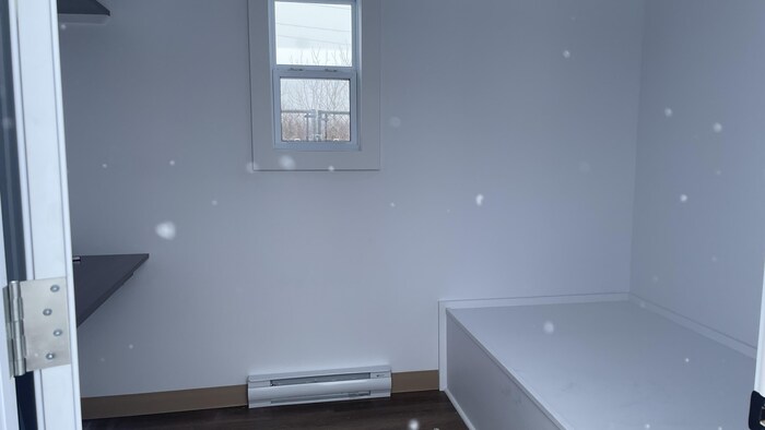 Porte ouverte sur une petite chambre.