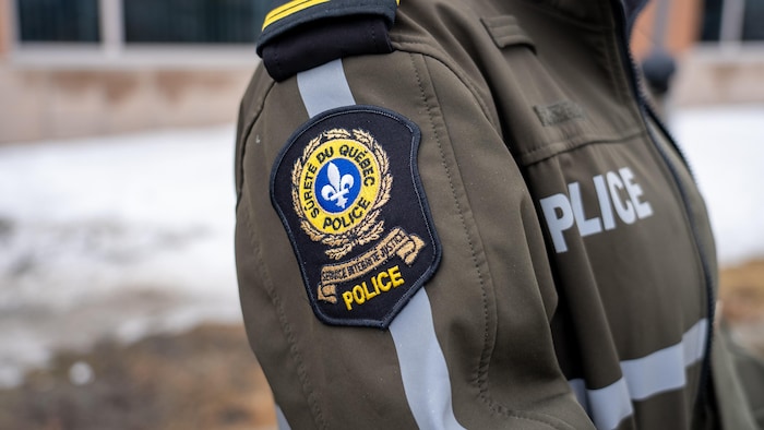 Une policière porte l'uniforme de la Sûreté du Québec.