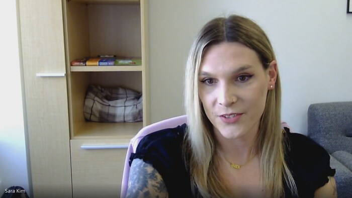 Sara Kim est assise à un bureau. 