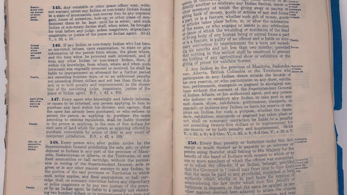 Un livre ouvert sur lequel on peut lire les articles de la Loi sur les Indiens.