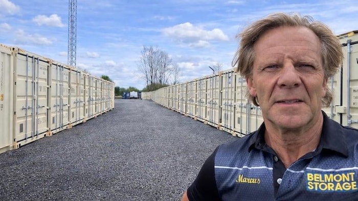 Marcus Kingo devant des conteneurs.