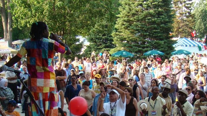 Un musicien se produisant sur scène au Sunfest devant une foule immense.
