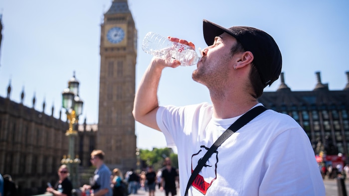 Un homme boit de l'eau à Londres où la température a atteint 34,8°C lundi. 